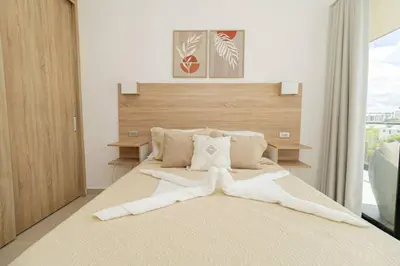 a bedroom with a large bed with a wooden headboard at Spacious 3BD Penthouse Private Rooftop Sea Breeze - Oasis in San Rafael del Yuma