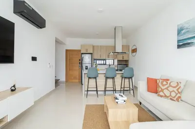 a living room with a white couch and blue chairs at Spacious 3BD Penthouse Private Rooftop Sea Breeze - Oasis in San Rafael del Yuma