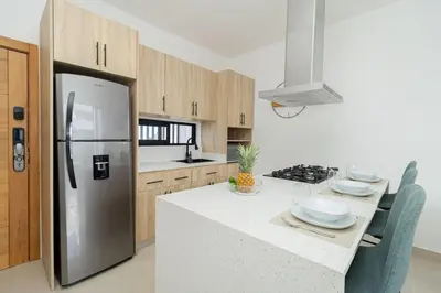 a kitchen with a refrigerator and a table with chairs at Spacious 3BD Penthouse Private Rooftop Sea Breeze - Oasis in San Rafael del Yuma