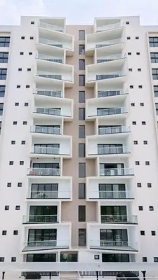 a tall white apartment building with balconies at Views, pool and gym, 2 BR family friendly in Santiago de los Caballeros