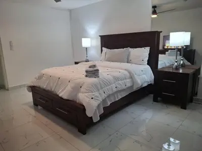 a bedroom with a large bed with two nightstands and two lamps at Beautiful condo in Sosua walking distance from everything in Sosúa