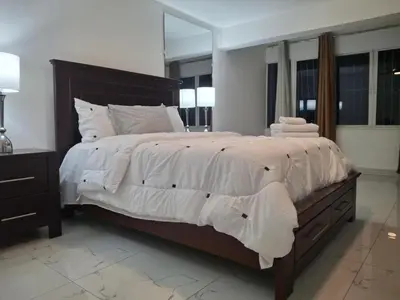 a bedroom with a large bed with white sheets and pillows at Beautiful condo in Sosua walking distance from everything in Sosúa