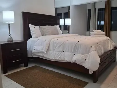 a bedroom with a large bed with white sheets and pillows at Beautiful condo in Sosua walking distance from everything in Sosúa