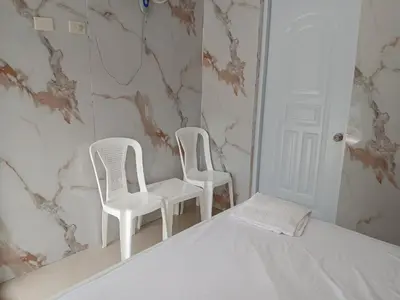 two white chairs and a bed in a room at Paraíso Vacacional FERNANDO in Polo