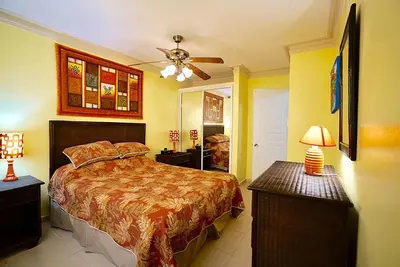 a bedroom with a bed and a ceiling fan at Garden condos in Sosúa