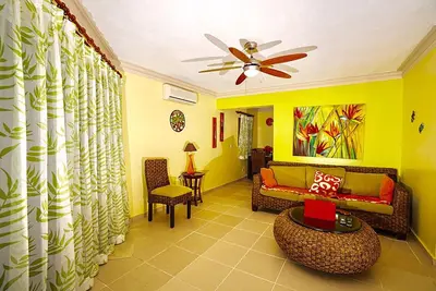 a living room with a couch and a ceiling fan at Garden condos in Sosúa