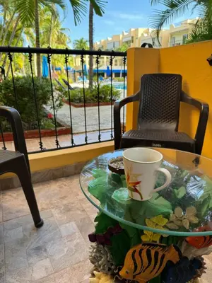 a glass table with a coffee cup on a balcony at Garden condos in Sosúa