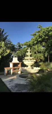 a group of white statues in a park with trees at Garden condos in Sosúa