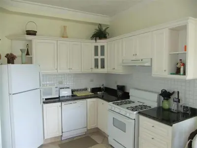 a white kitchen with white appliances and white cabinets at Los Balcones in Sosúa