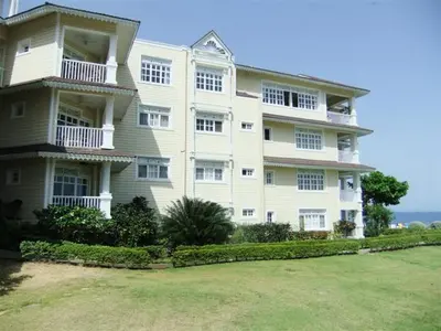 a large white building with a yard in front of it at Los Balcones in Sosúa