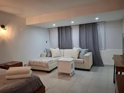 a living room with a couch and a bed at Modern condo in middle of Sosua in Sosúa
