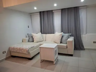 a living room with a couch and a table at Modern condo in middle of Sosua in Sosúa