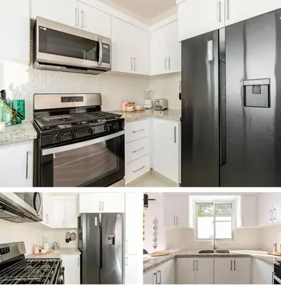 a kitchen with white cabinets and a black refrigerator at Luxury first floor Apartment Pool kingside suite in Santiago de los Caballeros