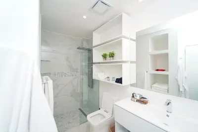 a white bathroom with a shower and a toilet at Cana Rock Star D208 Jaccuzi Pool Golf and Private Beach in Punta Cana