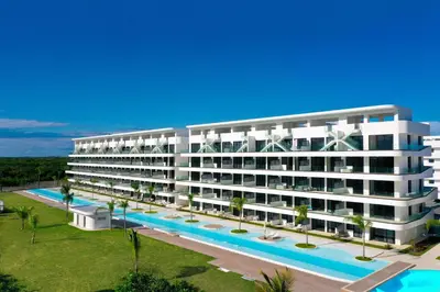 a large white building with a swimming pool at Cana Rock Star D208 Jaccuzi Pool Golf and Private Beach in Punta Cana