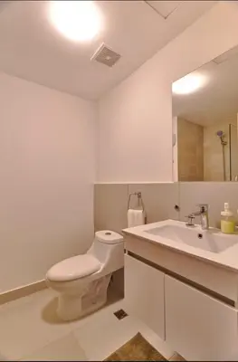a white bathroom with a toilet and a sink at Juan Dolio RD Beach Retreat in Juan Dolio