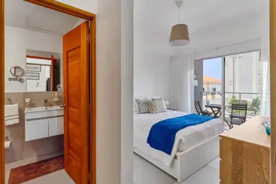 a bedroom with a bed and a bathroom with a balcony at Juan Dolio RD Beach Retreat in Juan Dolio