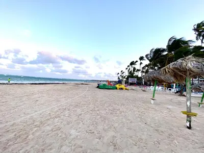 a sandy beach with umbrellas and the ocean at Los corales 1Bedroom Apartament Close to the Beach Central los corales RD in Punta Cana