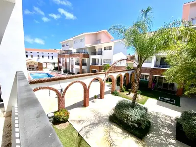 an apartment complex with a courtyard with a palm tree at Los corales 1Bedroom Apartament Close to the Beach Central los corales RD in Punta Cana