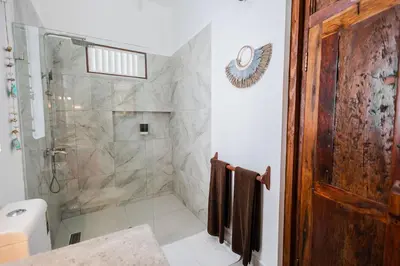 a bathroom with a shower with a glass door at Bali Style Boutique Hotel in Las Terrenas