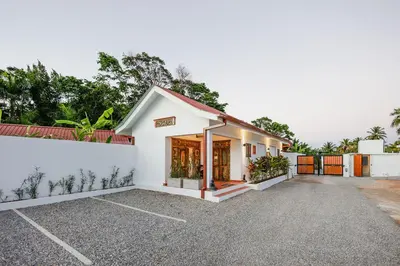 a small white building with a parking lot at Bali Style Boutique Hotel in Las Terrenas