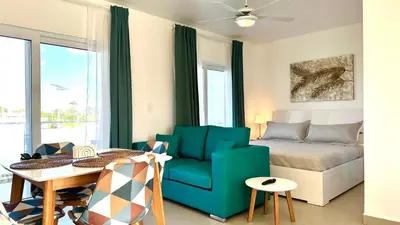 a living room with a couch and a table and a bed at Rheia Properties - SANTA FE in Sosúa