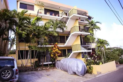 a yellow building with a cover in front of it at nNomad Apartment steps to Sirena - Apartment in Sosúa