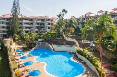 an aerial view of a resort pool with umbrellas at nNomad Studio mins from Sirena - Apartment in Sosúa