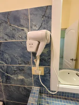 a white hairdryer hanging on a wall in a bathroom at KERY-OASIS 2bdr with pool close to the Beach in Las Terrenas