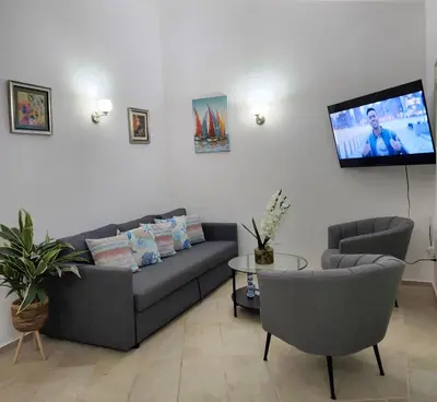a living room with a couch and a flat screen tv at KERY-OASIS 2bdr with pool close to the Beach in Las Terrenas