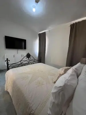 a bedroom with a white bed and a flat screen tv at Villa con Piscina en la Romana in La Romana