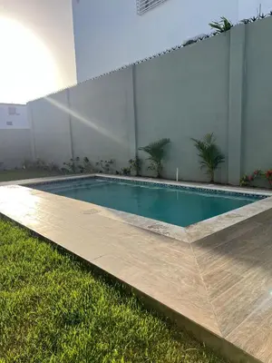 a swimming pool in a yard with a wooden deck at Villa con Piscina en la Romana in La Romana
