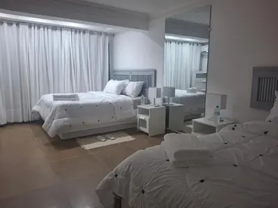 a bedroom with two beds and a large mirror at Amazing condo in the hearth of Sosua PERFECT LOCATION in Sosúa