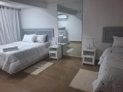 a bedroom with two beds and two night stands at Amazing condo in the hearth of Sosua PERFECT LOCATION in Sosúa