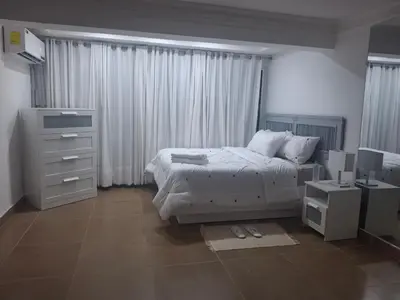a white bedroom with a bed and a dresser and a dresser at Amazing condo in the hearth of Sosua PERFECT LOCATION in Sosúa