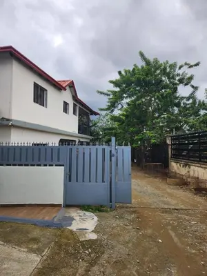 a blue gate in front of a white house at Remanso 1 in Jarabacoa