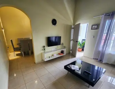 a living room with a tv and a table at Remanso 1 in Jarabacoa