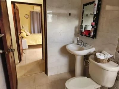 a bathroom with a sink and a toilet and a mirror at Remanso 1 in Jarabacoa