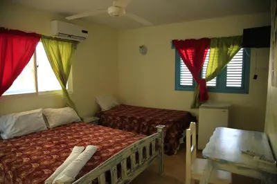 a bedroom with two beds and two windows at Casa Brisa Mar Hotel in Las Terrenas