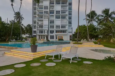 two chairs sitting in the grass in front of a building at Luxurious Caribbean Aquarella 10th in La Puntica de Juan Dolio