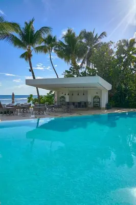 a pool in front of a resort with palm trees at Luxurious Caribbean Aquarella 10th in La Puntica de Juan Dolio
