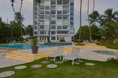two chairs sitting in the grass in front of a building at Aquarella Caribbean Blue Summer Special GateAway in La Puntica de Juan Dolio