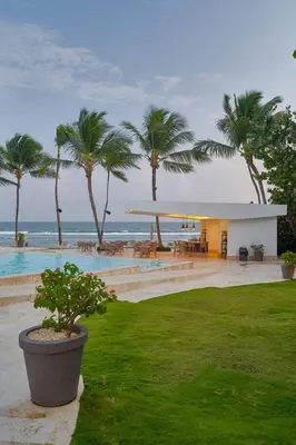 a resort with a pool and palm trees and the ocean at Aquarella Caribbean Blue Summer Special GateAway in La Puntica de Juan Dolio