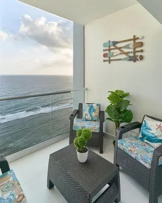 a living room with chairs and a balcony with the ocean at Aquarella Caribbean Blue Summer Special GateAway in La Puntica de Juan Dolio