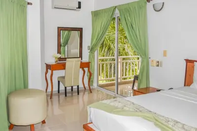 a bedroom with a bed and a desk and a mirror at Hotel Restaurant Chino in Santa Bárbara de Samaná
