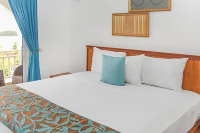a bedroom with a bed with white sheets and a window at Hotel Restaurant Chino in Santa Bárbara de Samaná