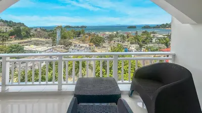 a balcony with two chairs and a view of the ocean at Hotel Restaurant Chino in Santa Bárbara de Samaná