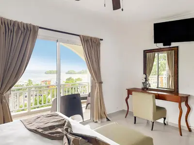 a bedroom with a bed and a desk and a window at Hotel Restaurant Chino in Santa Bárbara de Samaná