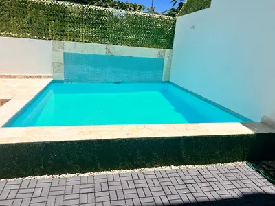 a blue swimming pool with a tile floor at Perla 8- Exclusiva Moderna Villa 4 Habitaciones y Piscina in Sosúa