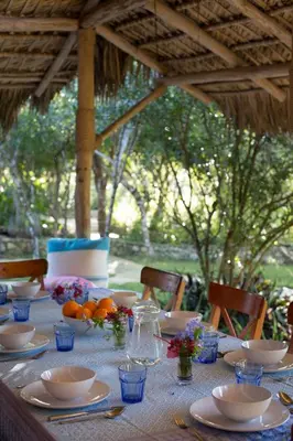 a table with plates and bowls on top at Ki-Ra Holistic Living in Boca de Chavón